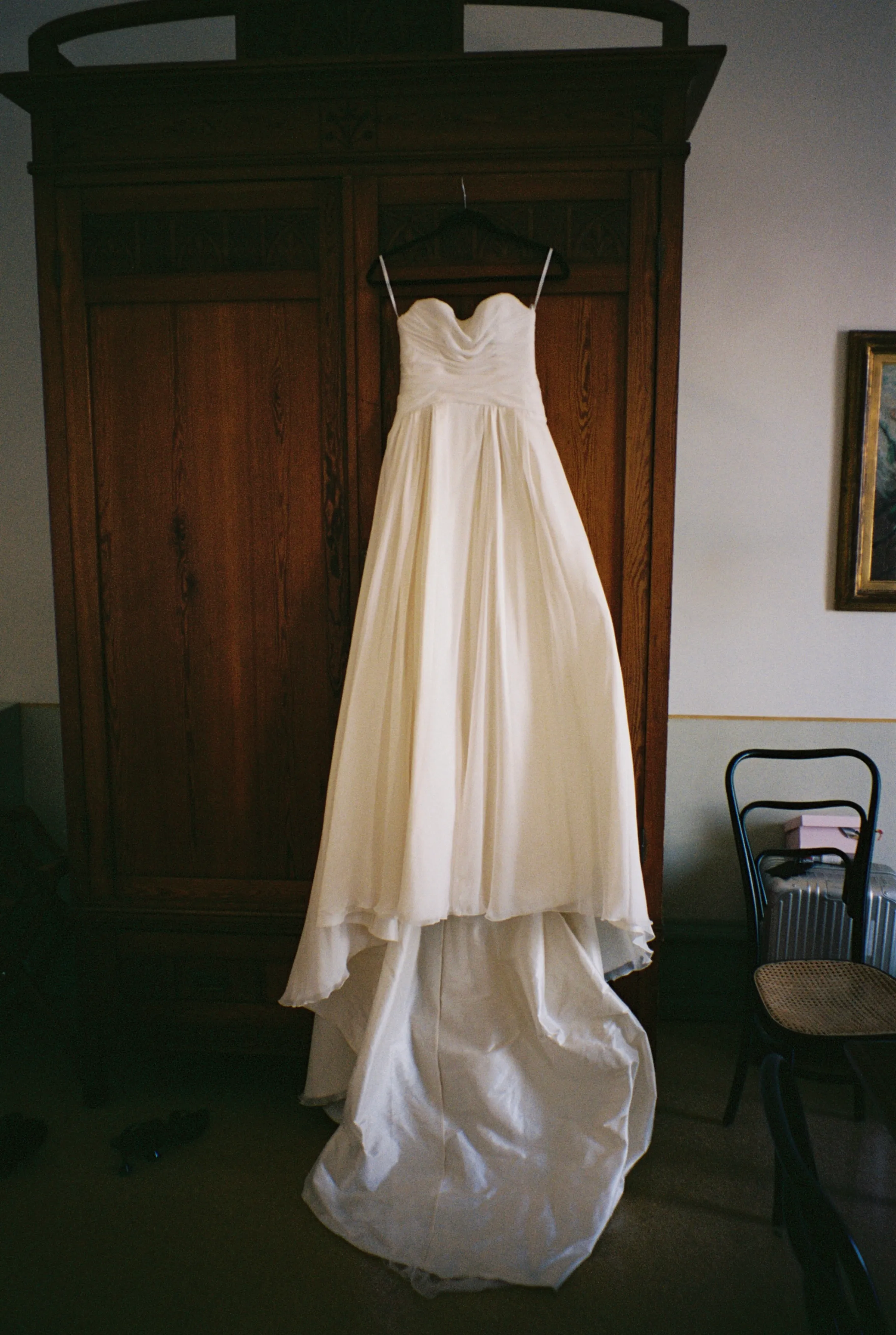 The wedding dress hanging on an antique wardrobe