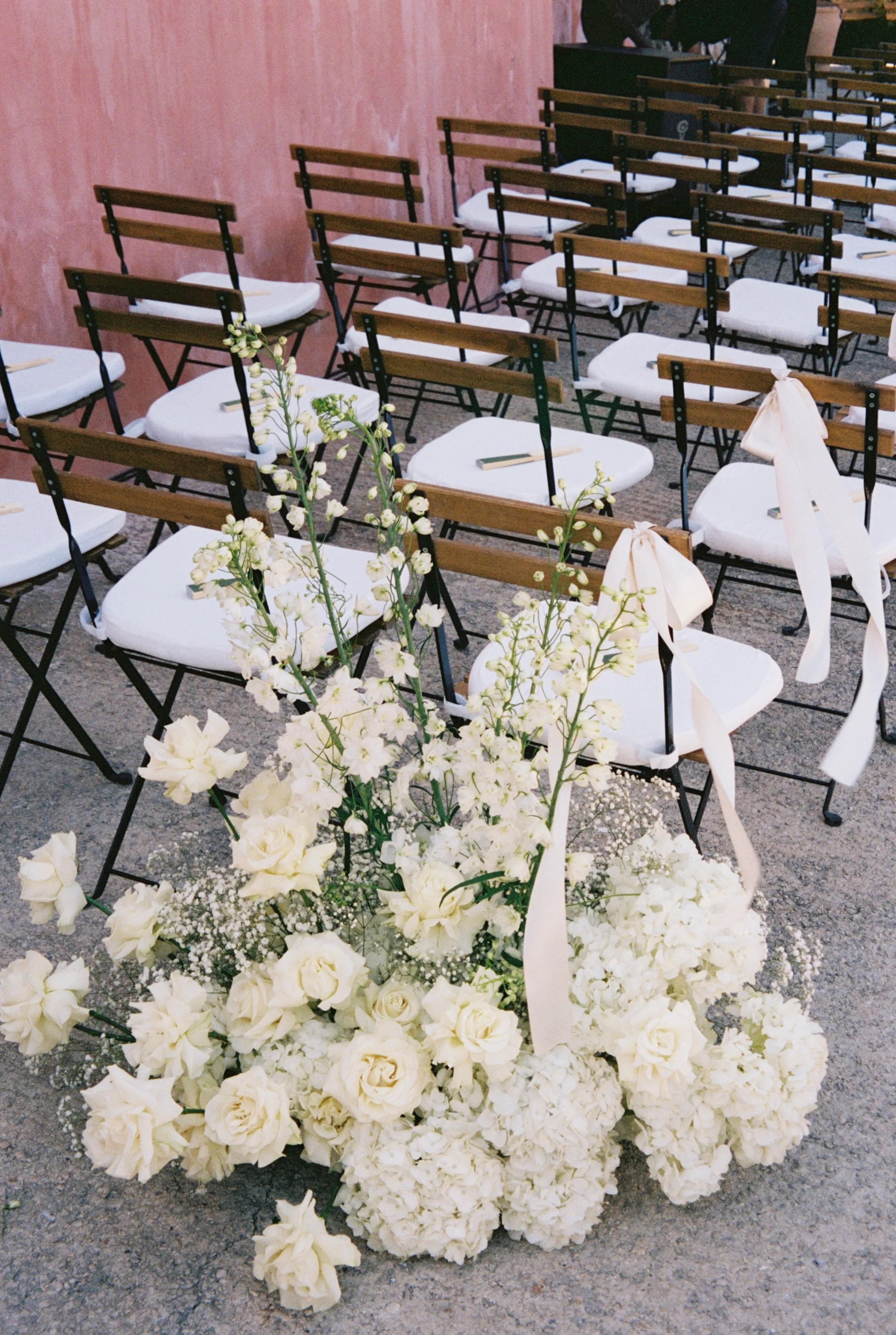 White floral arrangement by the ceremony chairs