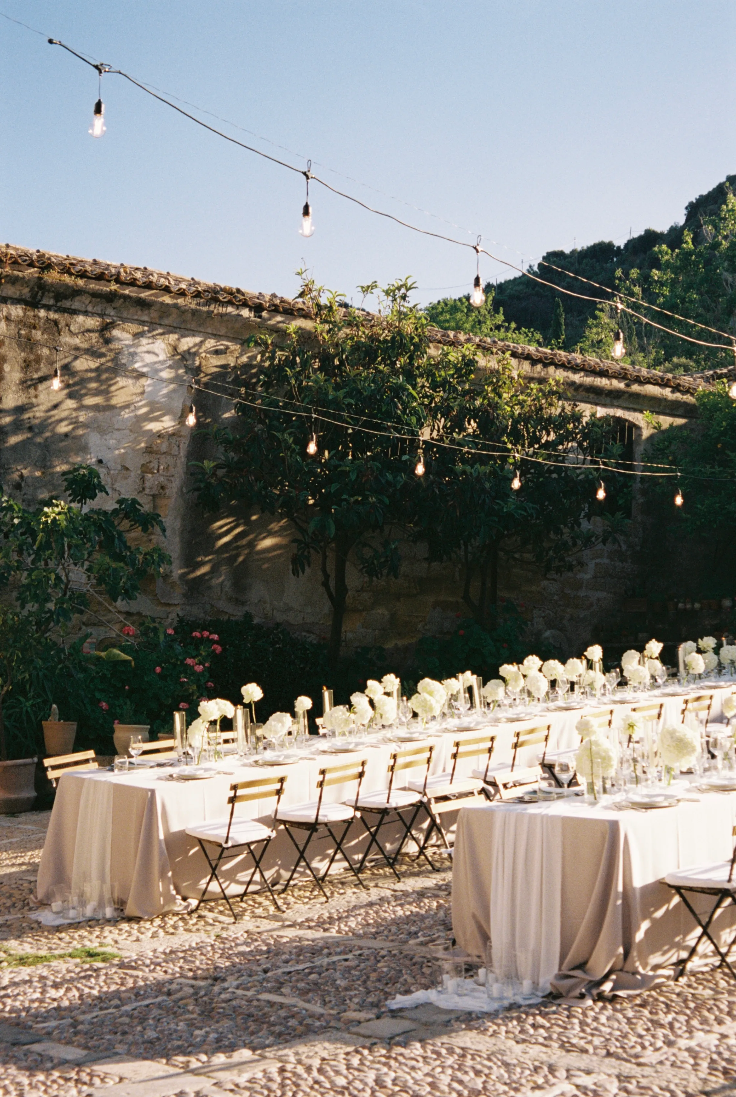 Long table with string lights set for dinner